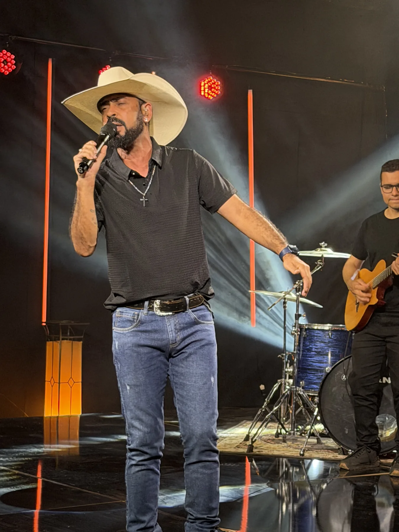 Tonny Ferrari de chapéu, cantando no palco com sua banda